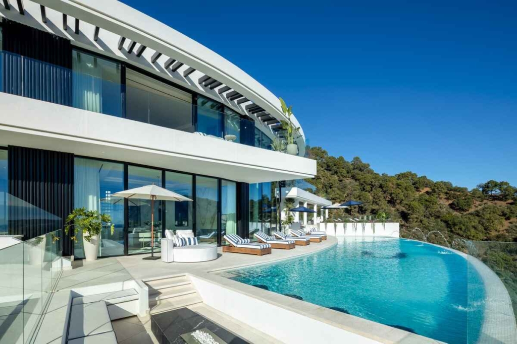 View of El Unico villa’s infinity pool with panoramic views of Marbella’s landscape and coastline.